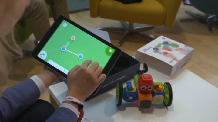 Child Using a Tablet to Program a Colorful Robotic Toy in A Modern Learning Environment