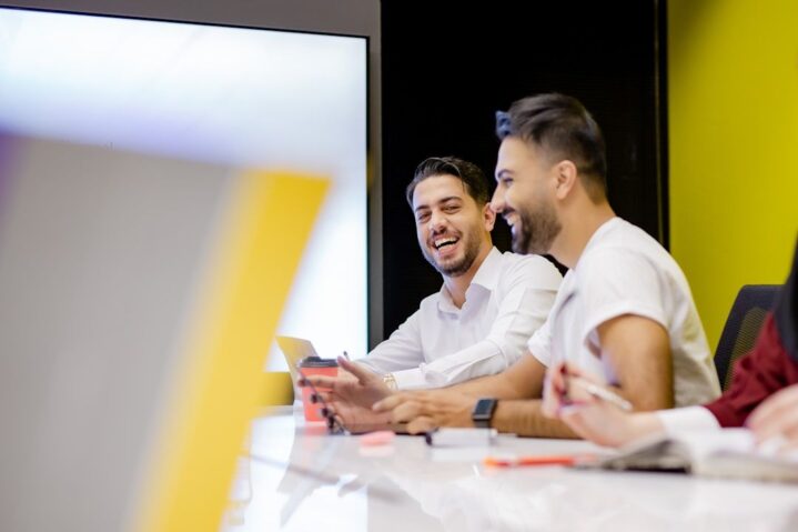Professionals are smiling during a meeting, illustrating what customer segmentation can achieve