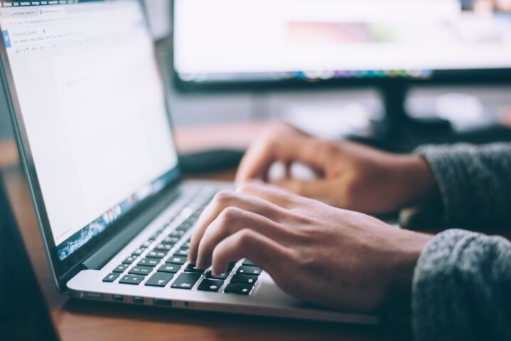 A professional typing on a laptop, demonstrating the use of an enterprise search system